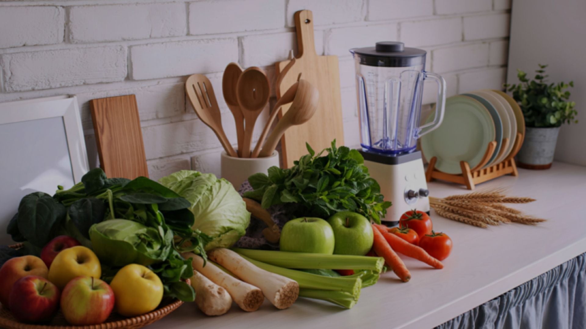 Kitchen counter with fruits, vegetables, and a blender against a white brick wall.