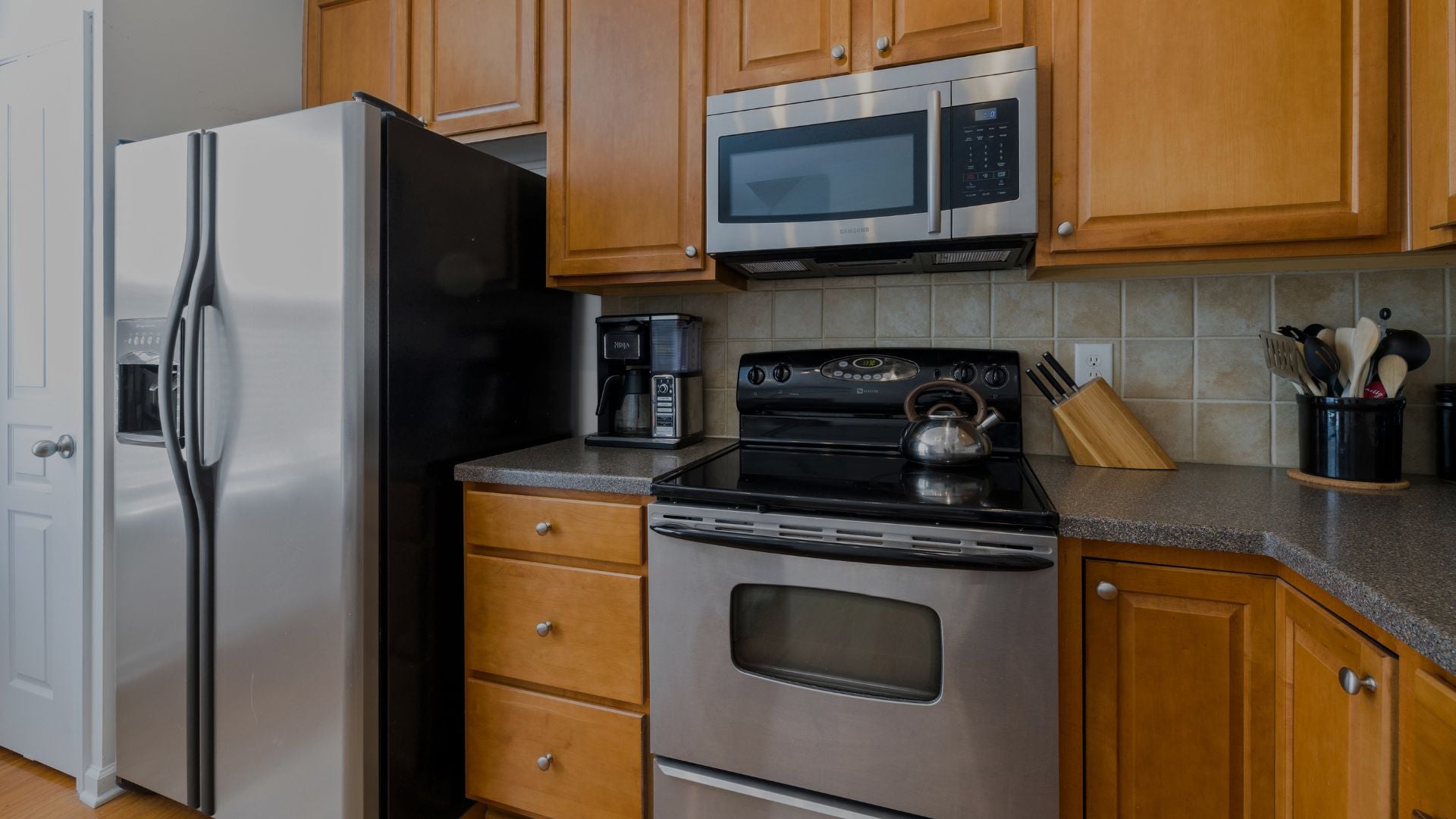 Kitchen with stainless steel appliances including refrigerator, microwave, and oven.